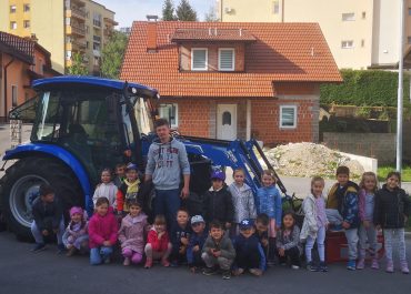 OTROCI IZ ENOTE ŠKRATEK IN VZGOJITELJ JANI Z NJEGOVIM TRAKTORJEM